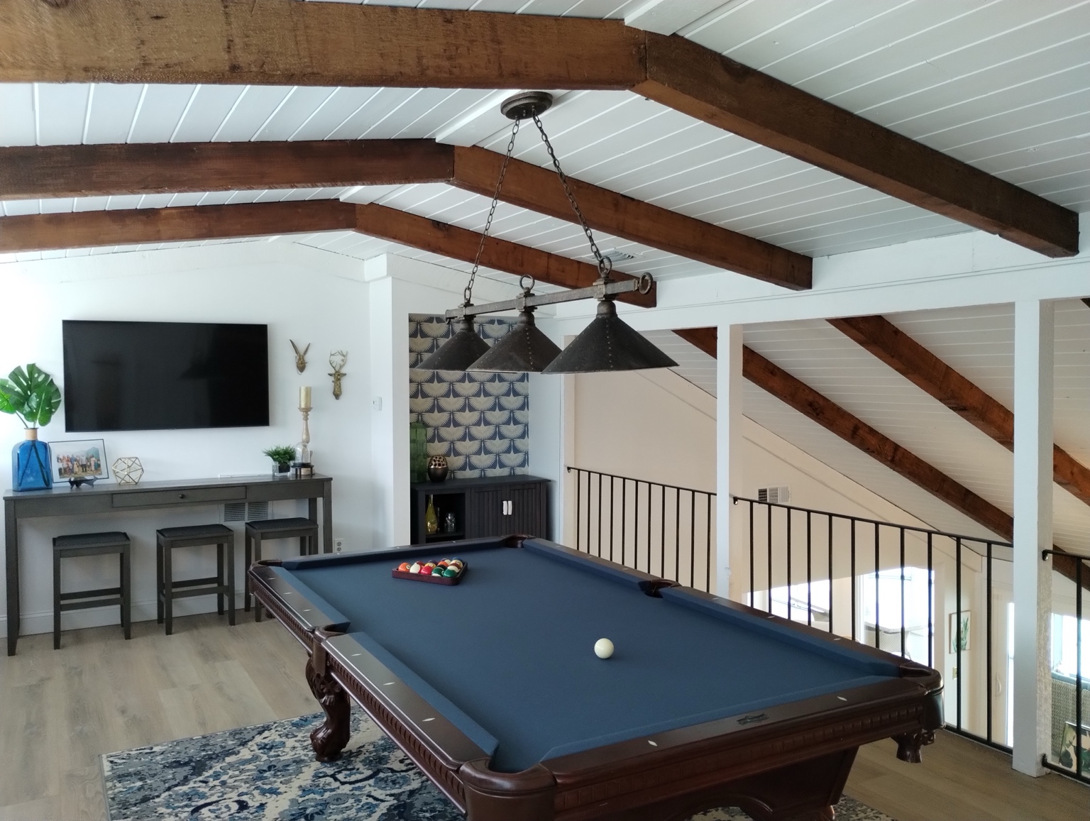 Pool table room with painted ceiling beams and finished interior surfaces